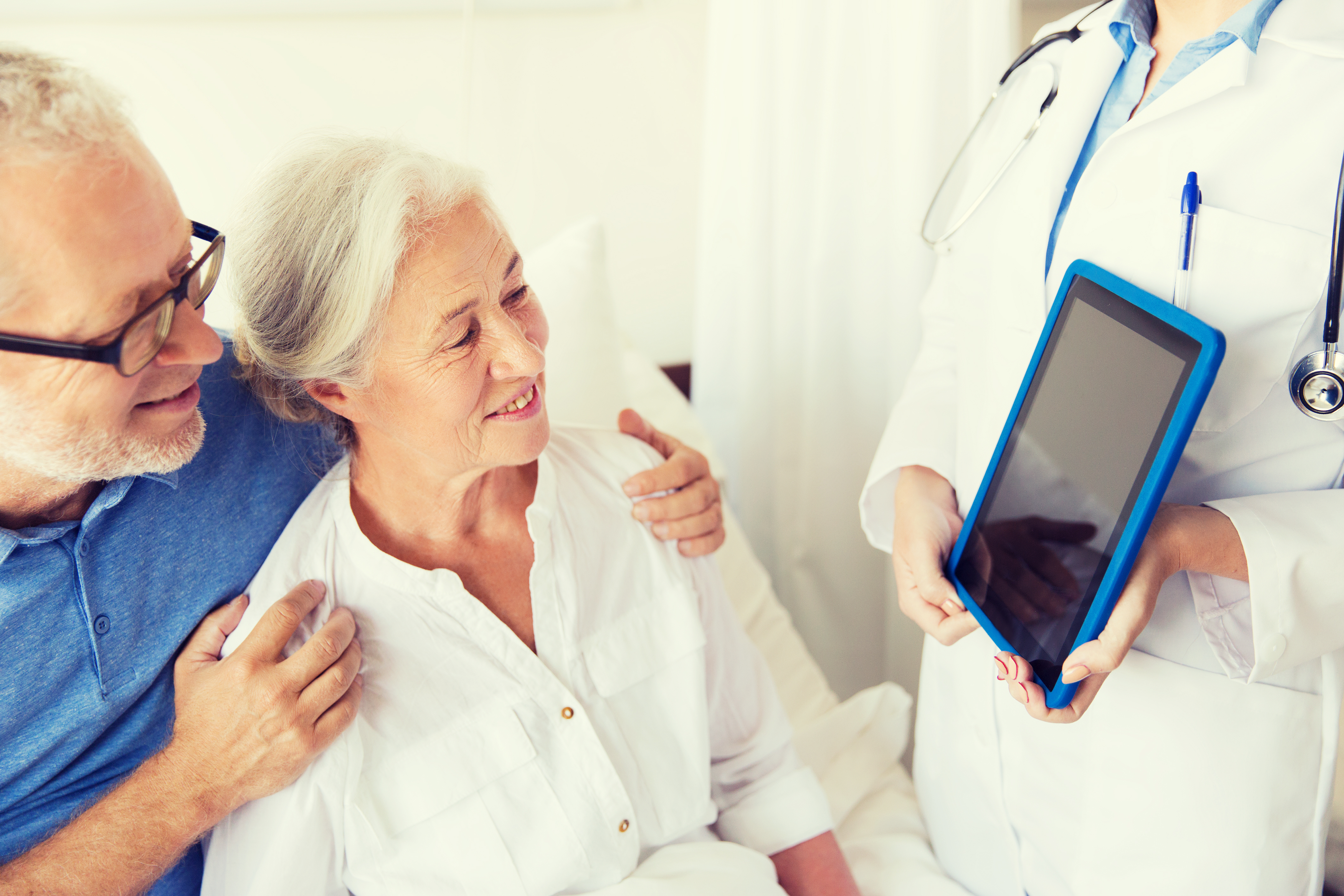 senior woman and doctor with tablet pc at hospital